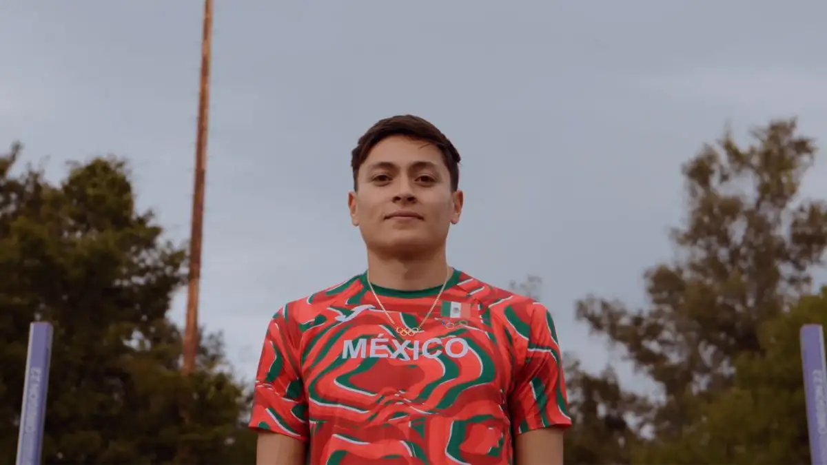 Imagen de Erick Portillo, atleta mexicano, sonriendo de medio cuerpo durante una entrevista bajo una ligera lluvia.  