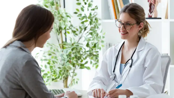 Doctora en consulta con paciente dandole recomendaciones en los hábitos para mejora de su salud