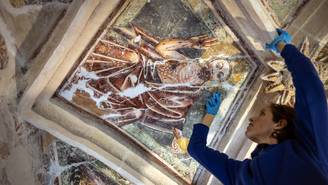 Mujer estudiando y restaurando una pintura de arte medieval en museo de arte